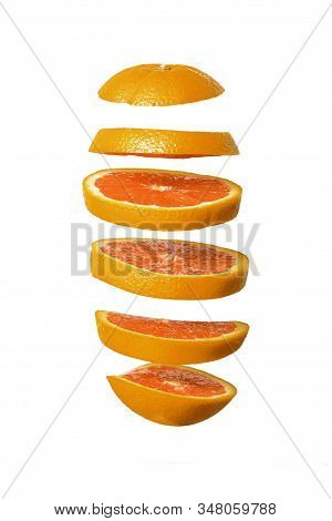 Creative Concept With Flying Orange. Sliced Orange Isolated On White Background. Levity Fruit Floati