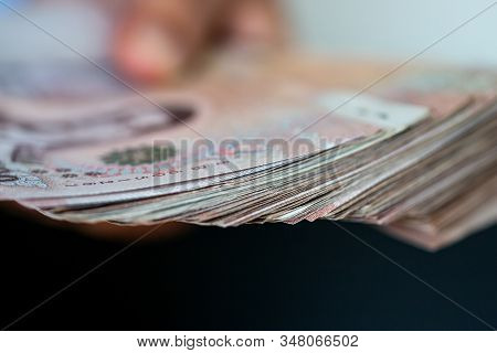 Blurred Of Stack Thai Baht Banknotes, One Thousand Baht With Tag Text In Thai Word. (thb) Is Officia