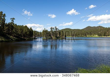 Stockade Lake In Custer State Park On A Clear Spring Day With Calm Water And People Enjoying The Wea