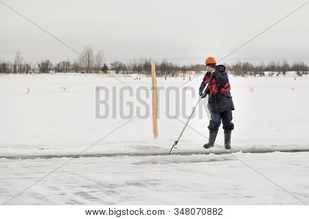 Worker Rafts Ice Blocks Along A Canal Carved In A Frozen Lake