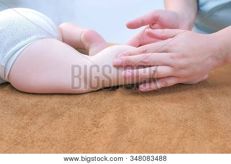 Professional Doctor Masseur Making Massage To Baby On Leg In Clinic, Legs Closeup View. Therapists H
