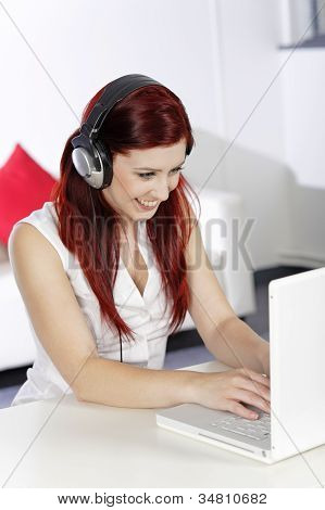 Mujer con auriculares trabajando en Laptop