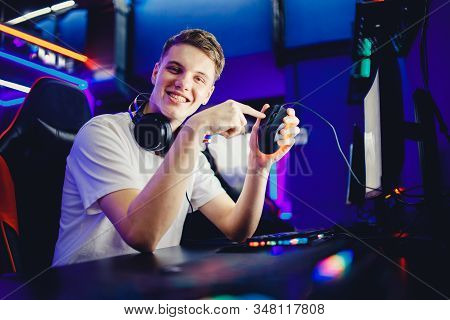Professional Young Man Player In Online Video Game Cybersportsman Advertises Headphones, Keyboard An