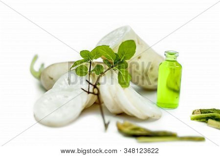 Freshly Sliced Daikon Radish Along With Its Extracted Essence In A Small Glass Bottle.