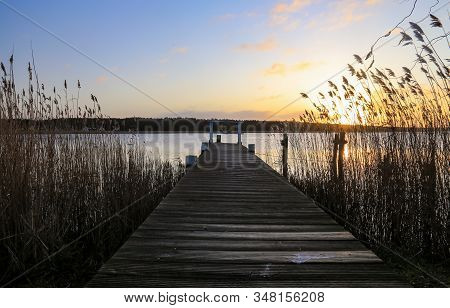 Old Wooden Pier At Small Beautiful Pond On Sunset