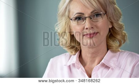 Senior Lady With Kind Eyes And Pleasant Smile Looking Into Camera Inducing Trust