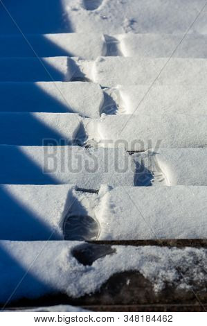 Footprints Of Boots On Snowy Steps. Stairs Covered With The Snow. Steps With Footprints In The Snow.
