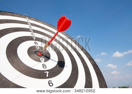 Dart Arrow Hit On Bulleyes Of Dartboard With Blue Sky, Planning New Business Target And Goals.