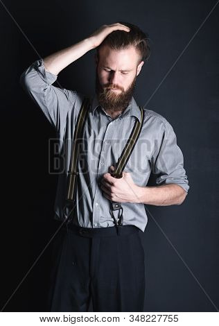 Young, Handsome Man With A Beard Posing On A Black Background In The Studio.