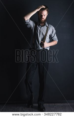 Young, Handsome Man With A Beard Posing On A Black Background In The Studio.