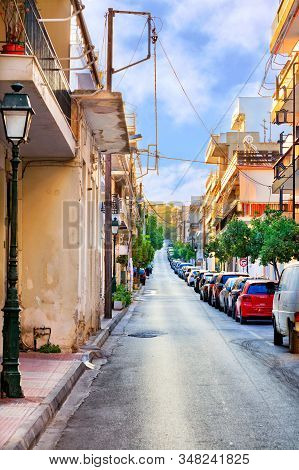 Narrow Carriageway Against A Background Of Parked Cars, A Deserted Street And Bright Morning Sunligh