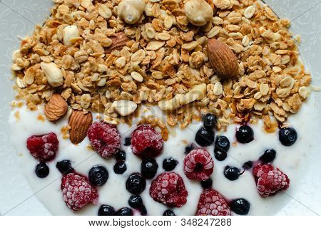 Healthy Breakfast, Granola With Yogurt And Frozen Raspberries And Blueberries, Closeup