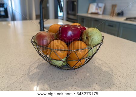 Wired Geometric Fruit Basket With Fresh Fruits At The Kitschen Island Of Home