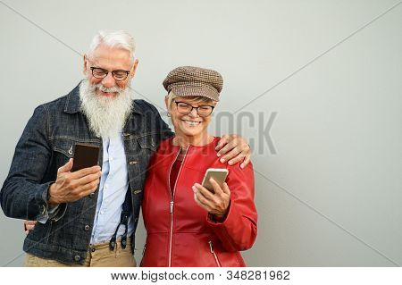 Happy Senior Couple Looking Videos In The Cellular Phone - Retired Persons Listening The Music - Eld