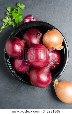 Red Ripe Onion In A Black Plate. Dark Background.