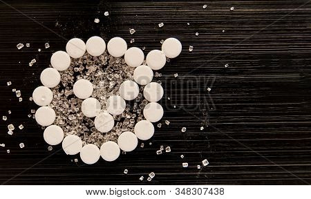 Sweetener Tablets Lying With Sugar On A Dark Background