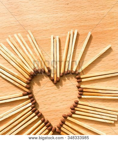 Wooden Safety Matches On A Wooden Background Arranged In The Shape Of A Heart. Matchsticks In The Sh