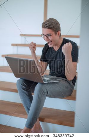 happy young man looking at his laptop screen