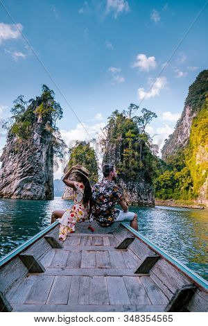 Couple Traveling By Boat Exploring Epic Limestone Cliffs In Huge Lake In Khao Sok National Park, Chi