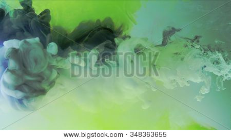 Multicolored Composition From Ink Streams. Black And White Streams Of Ink Float And Mix In The Cente