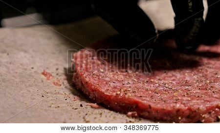 Cook Makes Meat Medallions For Burgers. Chef In Black Food Gloves Makes Cutlet. Cutlets Are Leveled 