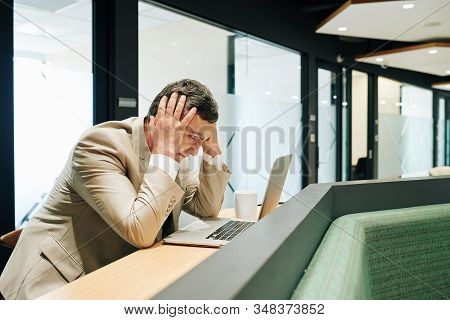 Horizontal Shot Of Mature Caucasian Office Worker Clutching His Head After Making Big Mistake Feelin
