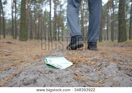 Young Man Loses His Euro Money Bills On Russian Autumn Fir Wood Path. Carelessness And Losing Money 