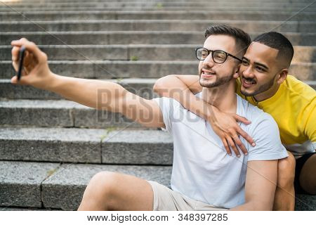 Gay Couple Taking A Selfie With Mobile Phone.
