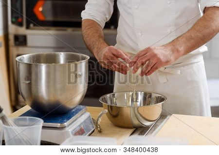 Baker Is Whipping Eggs And Using Scale To Measure Weight