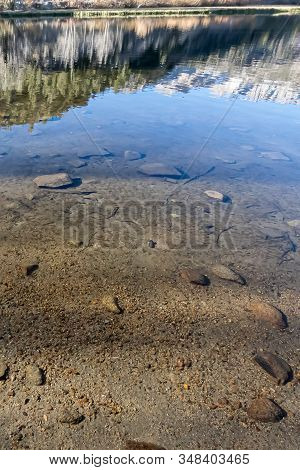 Lake Bed Through Transpatent Water With Reflections And Shadows