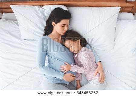 Beautiful Pregnant Mother And Little Daughter Sleeping Together, Top View