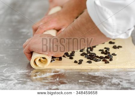 Man Is Rolling Viennoiserie Dough With Raisins