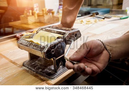 Chef Rolling Dough With A Pasta Machine. Pasta Maker Machine.