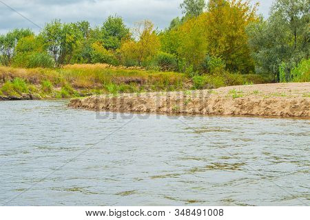 A Long Sand Spit In The Form Of A Beach At The Turn Of The River, Which Enters The Water Against The