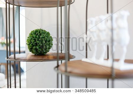 Separate parts of the interior of the living room. Wooden shelves with metal inserts. Green cube.