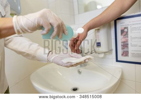 Nurse Disinfects A Patients Hand At A Sink