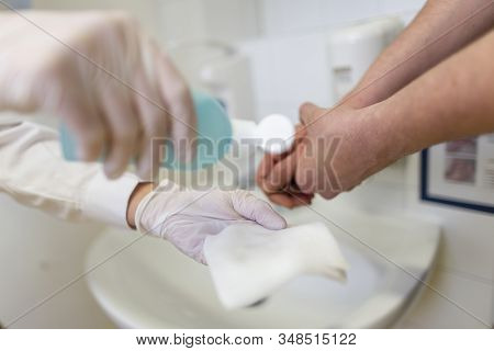 Nurse Disinfects A Patients Hand At A Sink