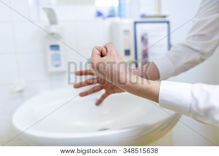 A Nurse Disinfects Her Hands In A Hospital Room