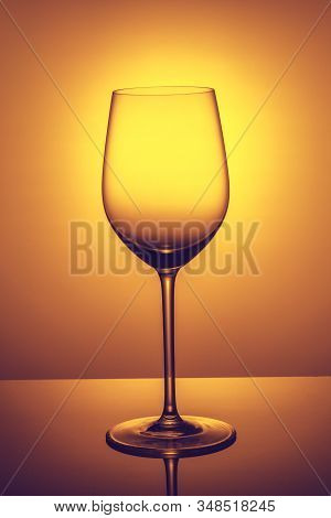 An Elegant Empty Glass Of Wine  Is Standing Opposite The Light, The Sun In The Glass