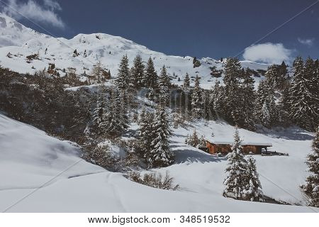 A Hut In The Snowy Mountains Of The South Tyrolean Alps. Hike In Ratschings Under Blue Skies.