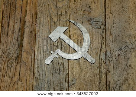 Sickle And Hammer Lying On Wooden Background