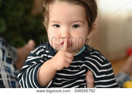 Baby And Silence. Shows A Finger. The Child Is 0-1 Years Old. A Small Child Shows A Finger With One 