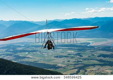 Hang Glider Man Flying In Beautiful Sunny Day With Kootenay Valley Mountains In The Background, Cres