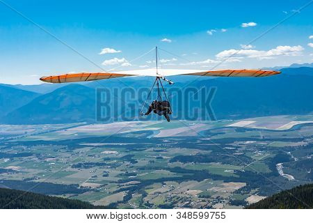 Hang Gliding In Action. Extremal Sportsman Enjoying His Recreational Journey To Creston, British Col
