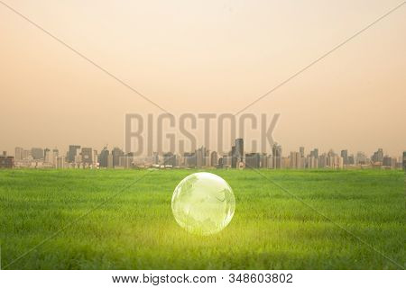 The  Globe With The Background Of Many Large Building. Global Warming And Pollution Theme . Conceptu
