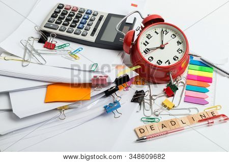Pile of documents, alarm clock, calc and office stuff - time menegment concept