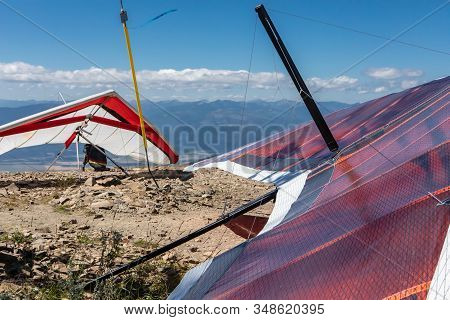 Two Hang-gliders Parked On The Hilltop. Extreme Lifestyle. Delta Planes Are Being Prepared For A Fli