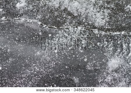 Texutured Ise Surface Of Frozen Lake. Close Up. Scattered White Snow Around. Winter Background.