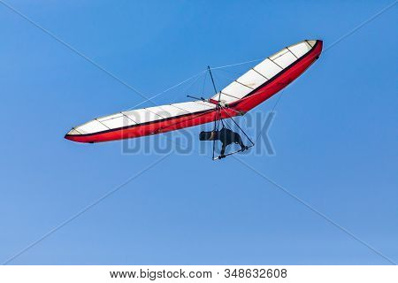 Soaring Hang Gliding In The Sky. View From The Bottom. Hang Glider Pilot Enjoying A Flight. Extremal
