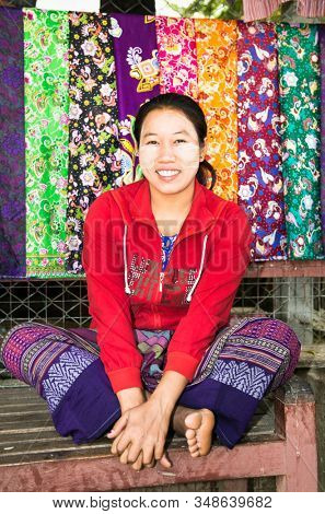 MINGUN,MYANMAR - MARC 6, 2017:Unidentified young Myanmar woman with thanaka on her smile face is happiness in Mingun on March 6, 2017. Thanaka is a yellowish-white cosmetic paste made from ground bark